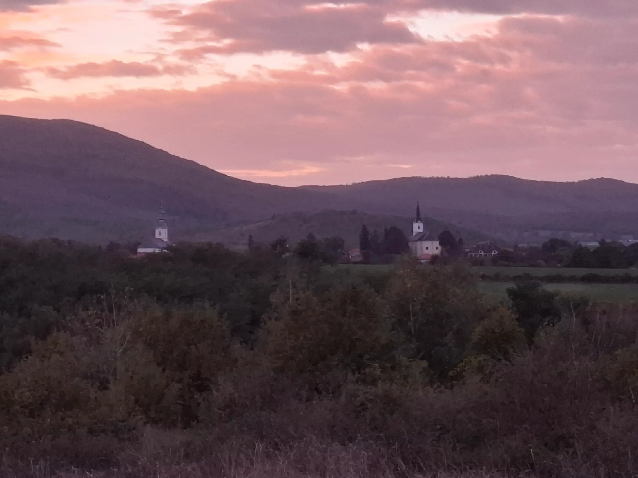 Kilátás a falu templomtornyaira és dombokra az első erkélyekről